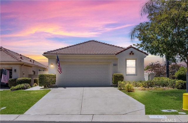 23681 Corte Sabio, Murrieta, CA 92562 - mediterranean / spanish home featuring concrete driveway, an attached garage, a tile roof, a yard, and stucco siding