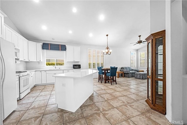 23681 Corte Sabio, Murrieta, CA 92562 - kitchen featuring white appliances, healthy amount of natural light, light countertops, a chandelier, and vaulted ceiling