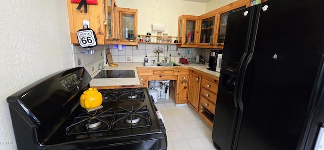 4141 Willow Trl, Frazier Park, CA 93225 - kitchen featuring black appliances, tile countertops, brown cabinetry, light floors, and decorative backsplash