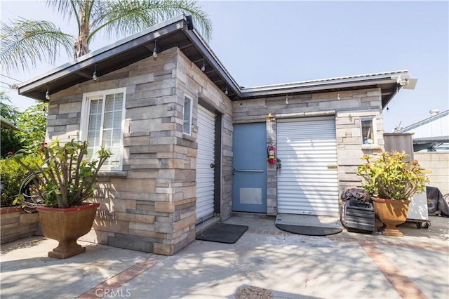 14724 Maclay St, San Fernando, CA 91345 - doorway to property featuring stone siding and a garage
