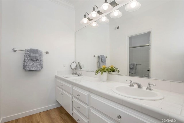 75 Shorebreaker Dr, Laguna Niguel, CA 92677 - bathroom featuring double vanity, a shower with shower door, wood finished floors, and ornamental molding