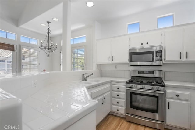 75 Shorebreaker Dr, Laguna Niguel, CA 92677 - kitchen featuring appliances with stainless steel finishes, a chandelier, tile countertops, healthy amount of natural light, and recessed lighting