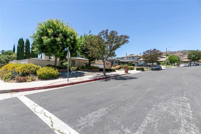 13119 Constable Ave, Granada Hills, CA 91344 - view of asphalt street with sidewalks, a residential view, street lighting, and curbs