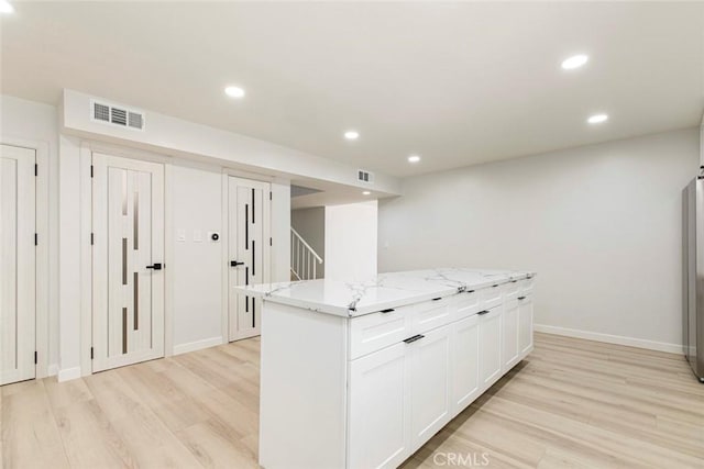 13119 Constable Ave, Granada Hills, CA 91344 - kitchen featuring light wood-style flooring, a center island, recessed lighting, white cabinets, and light stone countertops