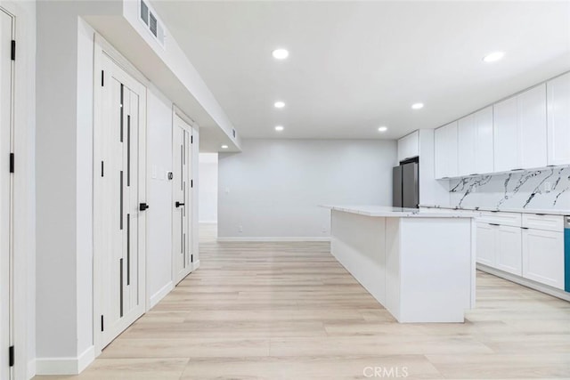 13119 Constable Ave, Granada Hills, CA 91344 - kitchen with recessed lighting, light wood-style flooring, white cabinets, freestanding refrigerator, and a kitchen island