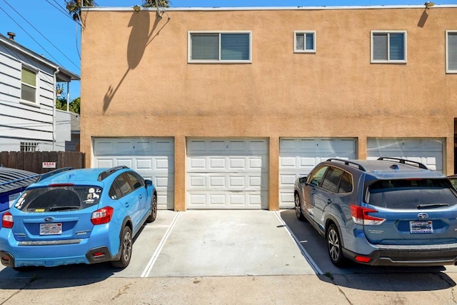 1361 Felspar St Unit 7, San Diego, CA 92109 - view of property featuring a garage, stucco siding, and driveway
