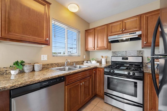 1361 Felspar St Unit 7, San Diego, CA 92109 - kitchen with under cabinet range hood, stainless steel appliances, brown cabinetry, and light tile patterned floors