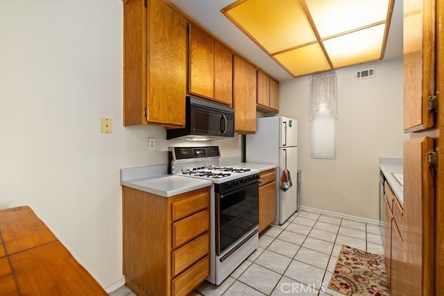 2823 W W Ave K12, Unit 136, Lancaster, CA 93536 - kitchen with white appliances, light countertops, brown cabinets, and light tile patterned flooring