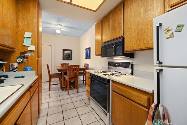 2823 W W Ave K12, Unit 136, Lancaster, CA 93536 - kitchen featuring white appliances, light countertops, a ceiling fan, and light tile patterned flooring