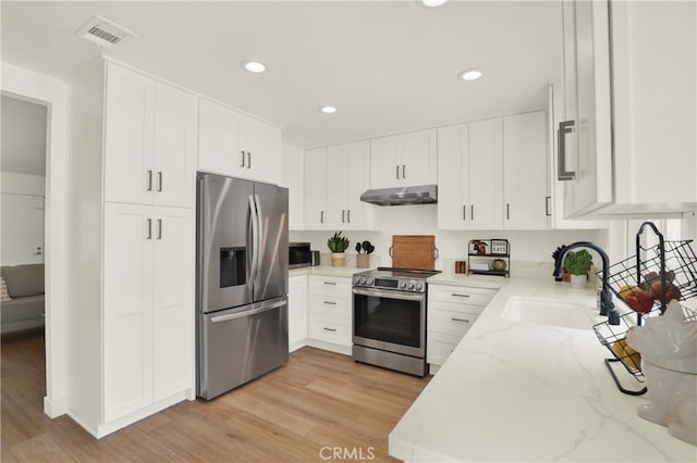 27322 Eastridge Dr, Lake Forest, CA 92630 - kitchen with stainless steel appliances, under cabinet range hood, light stone countertops, recessed lighting, and light wood-type flooring