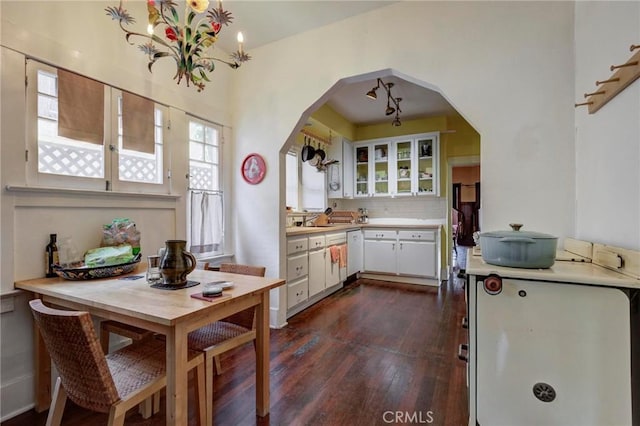 571 W 17th St, San Pedro, CA 90731 - kitchen with arched walkways, dark wood-style flooring, light countertops, white cabinets, and glass insert cabinets