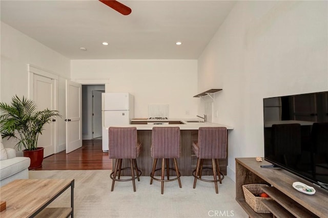 571 W 17th St, San Pedro, CA 90731 - kitchen with freestanding refrigerator, a peninsula, a kitchen breakfast bar, ceiling fan, and light countertops