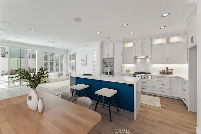 49 Eaglecreek, Irvine, CA 92618 - kitchen with open floor plan, light wood-type flooring, white cabinetry, light countertops, and stainless steel appliances
