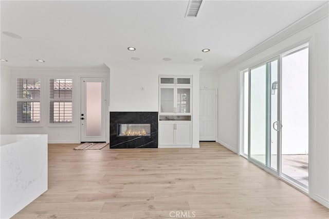 49 Eaglecreek, Irvine, CA 92618 - unfurnished living room with crown molding, a glass covered fireplace, light wood-style floors, and recessed lighting