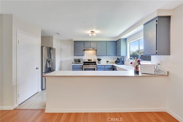 3966 Laurel Ct, Chino Hills, CA 91709 - kitchen with appliances with stainless steel finishes, light wood-type flooring, light countertops, a peninsula, and tasteful backsplash