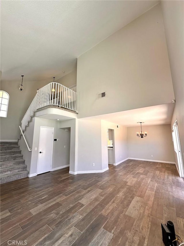 13067 Winterpark Way, Riverside, CA 92503 - unfurnished living room with high vaulted ceiling, a chandelier, wood finished floors, and stairs