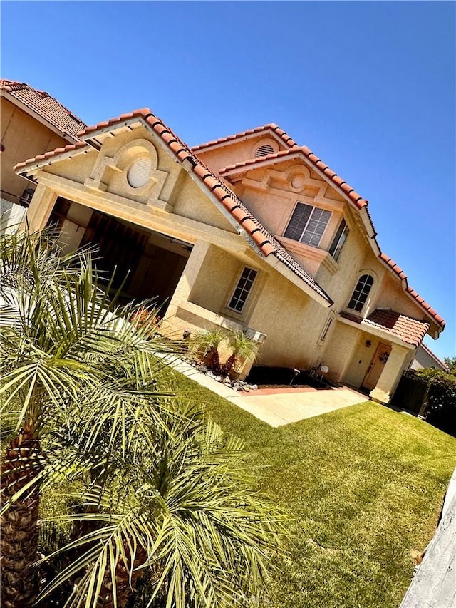 13067 Winterpark Way, Riverside, CA 92503 - view of front facade featuring a tile roof, a front yard, a patio area, and stucco siding