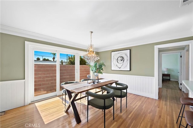 9662 Crosby Ave, Garden Grove, CA 92844 - dining area featuring wainscoting, wood finished floors, a chandelier, and crown molding