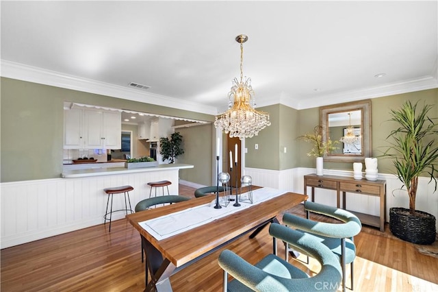 9662 Crosby Ave, Garden Grove, CA 92844 - dining space with a wainscoted wall, wood finished floors, a chandelier, ornamental molding, and recessed lighting