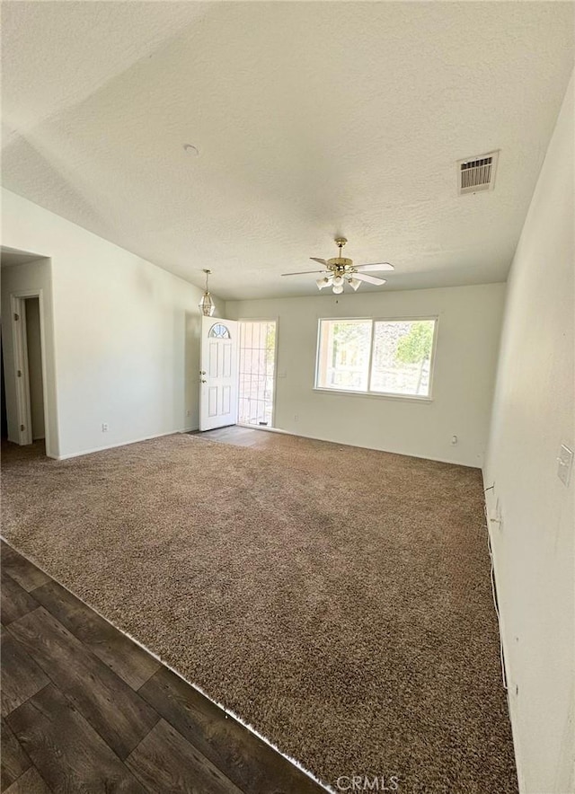 32161 Zircon Rd, Lucerne Valley, CA 92356 - spare room with ceiling fan, a textured ceiling, dark wood-style flooring, and dark carpet