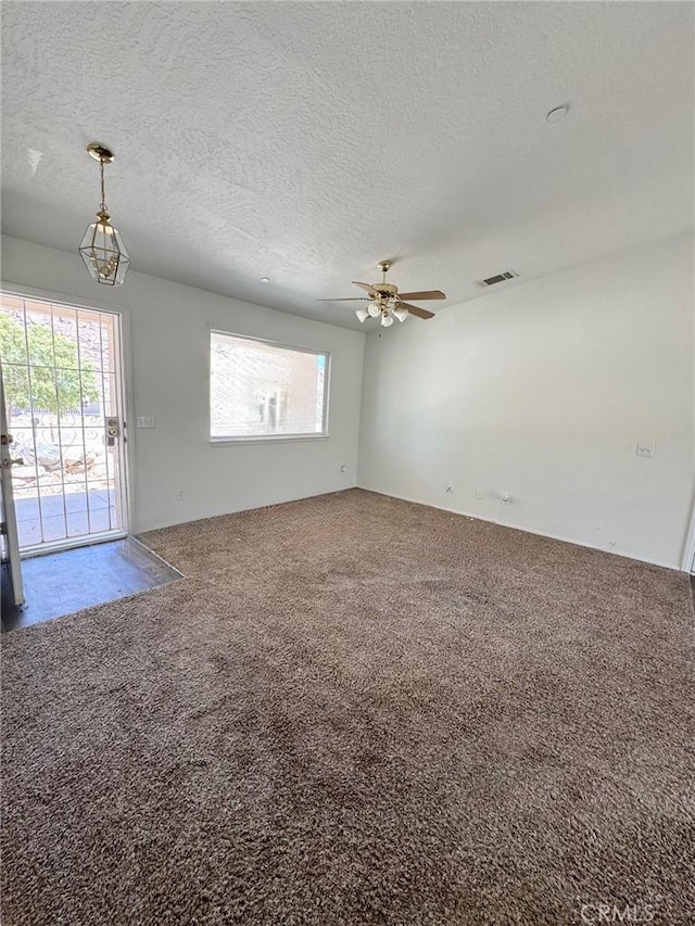 32161 Zircon Rd, Lucerne Valley, CA 92356 - unfurnished living room with carpet floors, a textured ceiling, plenty of natural light, and ceiling fan