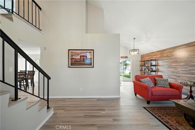 1440 Amanda Pl, Upland, CA 91784 - living room featuring stairway, high vaulted ceiling, wood finished floors, wood walls, and an accent wall