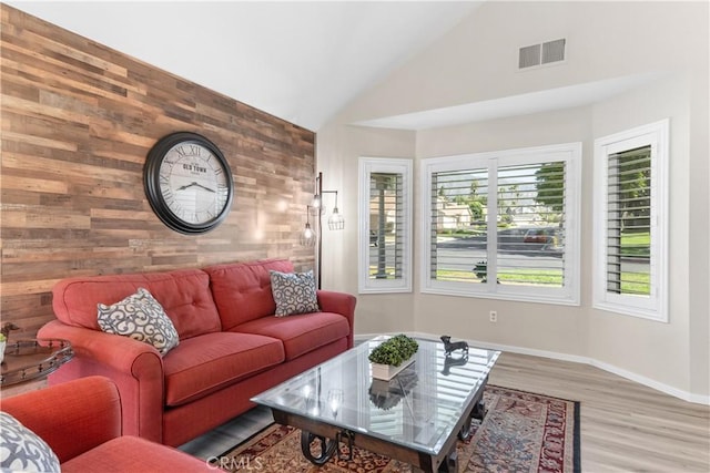 1440 Amanda Pl, Upland, CA 91784 - living room featuring wooden walls, an accent wall, light wood-style floors, and high vaulted ceiling