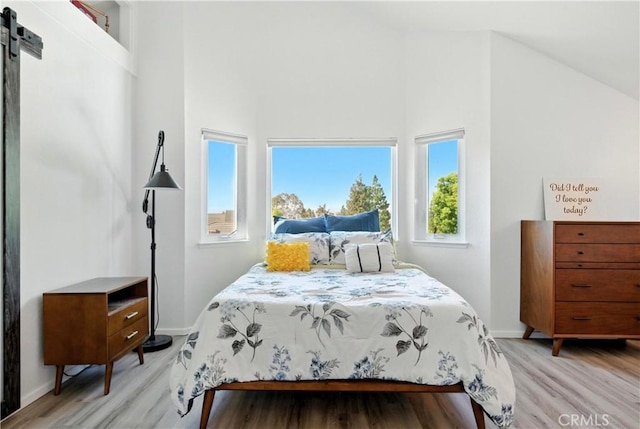 1440 Amanda Pl, Upland, CA 91784 - bedroom featuring light wood-style floors, a high ceiling, and a barn door