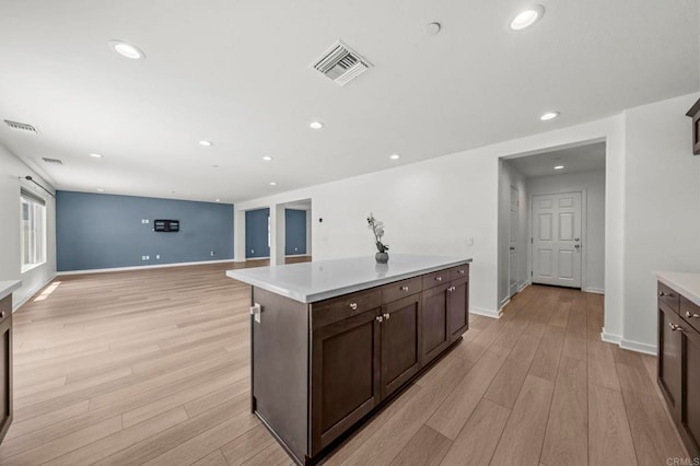 28339 Levi Way, Menifee, CA 92585 - kitchen featuring light wood-style floors, light countertops, dark brown cabinetry, recessed lighting, and a kitchen island