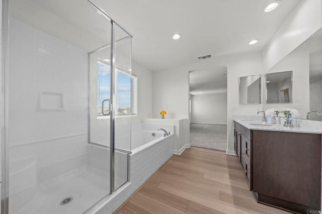 28339 Levi Way, Menifee, CA 92585 - bathroom featuring double vanity, a garden tub, a shower stall, wood finished floors, and recessed lighting