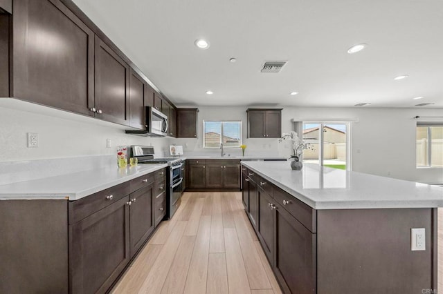 28339 Levi Way, Menifee, CA 92585 - kitchen with stainless steel appliances, a center island, light wood-type flooring, recessed lighting, and dark brown cabinets