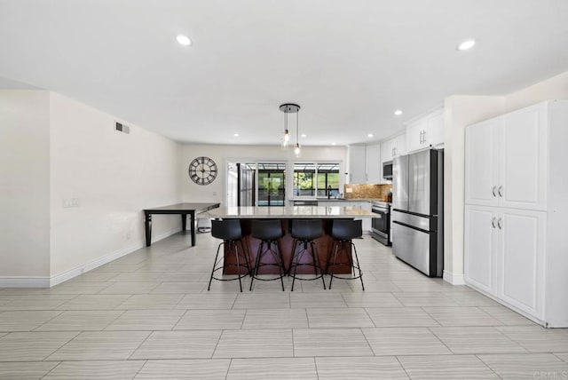 7971 Jade Coast Rd, San Diego, CA 92126 - kitchen featuring stainless steel appliances, a breakfast bar area, a kitchen island, white cabinets, and recessed lighting