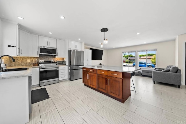 7971 Jade Coast Rd, San Diego, CA 92126 - kitchen featuring appliances with stainless steel finishes, decorative backsplash, open floor plan, recessed lighting, and pendant lighting