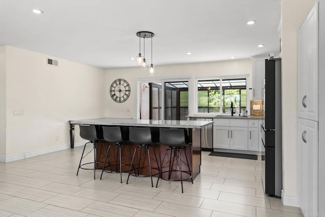 7971 Jade Coast Rd, San Diego, CA 92126 - kitchen with freestanding refrigerator, a breakfast bar area, dishwasher, a center island, and recessed lighting