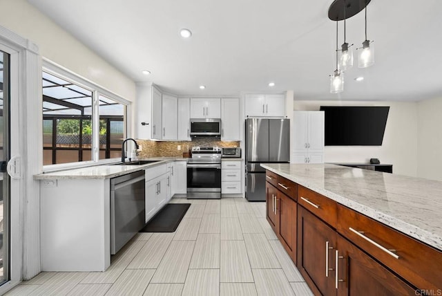 7971 Jade Coast Rd, San Diego, CA 92126 - kitchen with appliances with stainless steel finishes, decorative backsplash, white cabinets, light stone counters, and pendant lighting