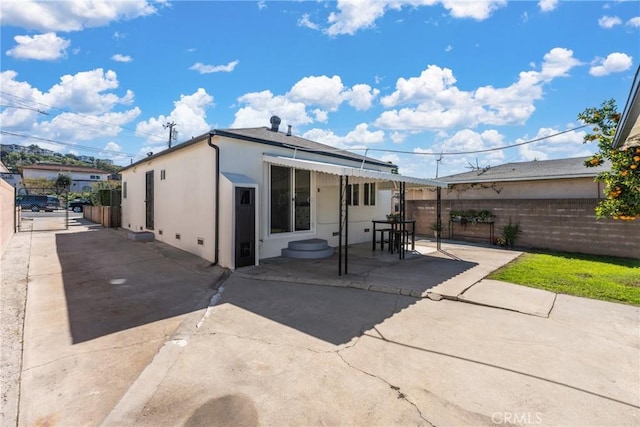 2283 Gaviota Ave, Signal Hill, CA 90755 - rear view of house with stucco siding and a patio