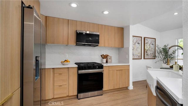 19081 Wildwood Cir, Lake Forest, CA 92679 - kitchen featuring appliances with stainless steel finishes, light brown cabinetry, backsplash, light countertops, and light wood-type flooring