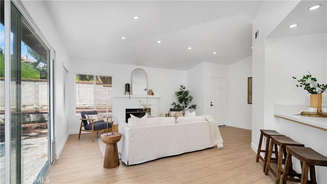 19081 Wildwood Cir, Lake Forest, CA 92679 - living area with light wood finished floors, a brick fireplace, and recessed lighting