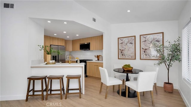 19081 Wildwood Cir, Lake Forest, CA 92679 - kitchen with appliances with stainless steel finishes, light wood finished floors, light countertops, recessed lighting, and a peninsula