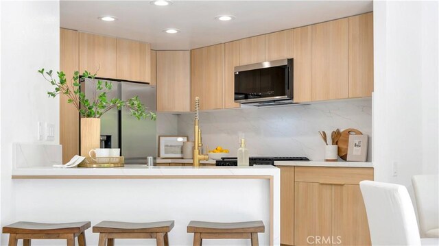 19081 Wildwood Cir, Lake Forest, CA 92679 - kitchen with stainless steel appliances, modern cabinets, a kitchen breakfast bar, recessed lighting, and light brown cabinetry