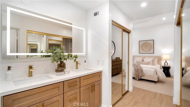 19081 Wildwood Cir, Lake Forest, CA 92679 - ensuite bathroom featuring wood finished floors, double vanity, and recessed lighting