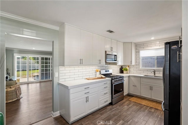 11243 Gaviota Ave, Granada Hills, CA 91344 - kitchen with appliances with stainless steel finishes, white cabinets, decorative backsplash, light countertops, and crown molding