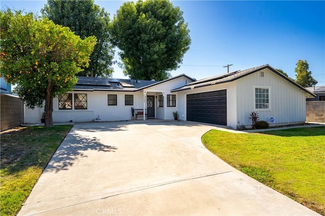 11243 Gaviota Ave, Granada Hills, CA 91344 - ranch-style house featuring concrete driveway, solar panels, an attached garage, and board and batten siding