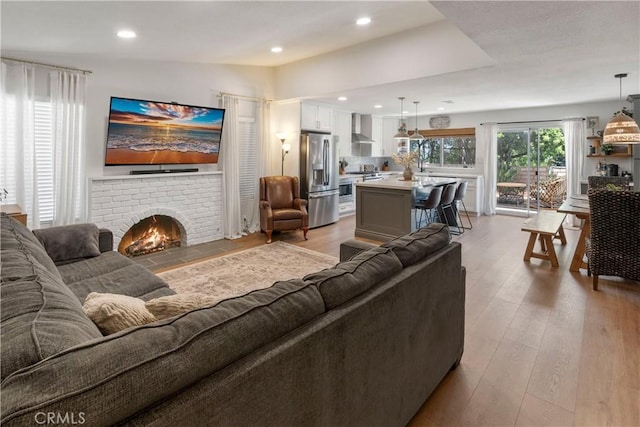 2151 Stonefield Pl, Riverside, CA 92506 - living area with light wood finished floors, a brick fireplace, and recessed lighting