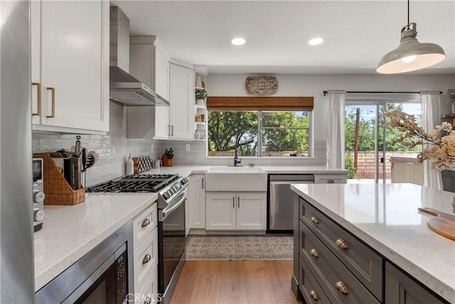 2151 Stonefield Pl, Riverside, CA 92506 - kitchen with appliances with stainless steel finishes, wall chimney exhaust hood, healthy amount of natural light, white cabinets, and recessed lighting