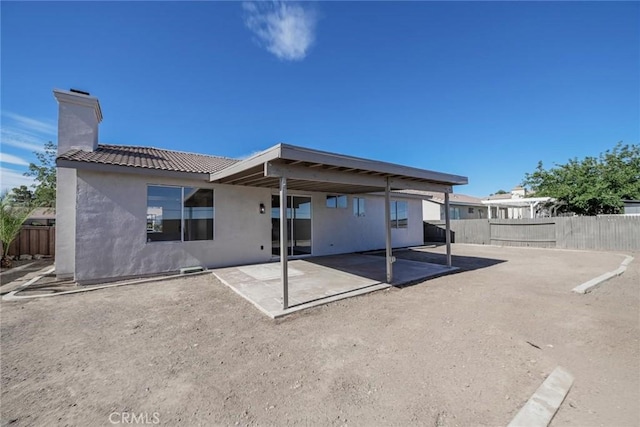 11490 Autumn St, Adelanto, CA 92301 - rear view of house with stucco siding, a patio, a tile roof, and a chimney