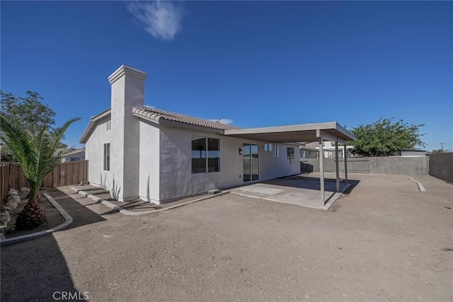 11490 Autumn St, Adelanto, CA 92301 - back of property with a patio, a fenced backyard, stucco siding, a chimney, and a tiled roof