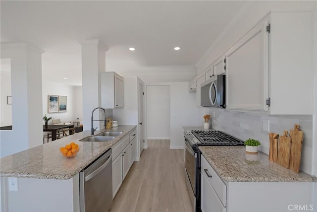 11490 Autumn St, Adelanto, CA 92301 - kitchen featuring appliances with stainless steel finishes, light wood-type flooring, backsplash, a peninsula, and light stone countertops