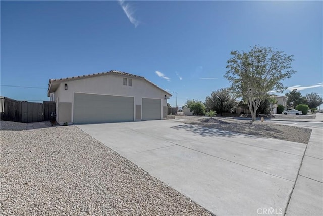 11490 Autumn St, Adelanto, CA 92301 - view of home's exterior with stucco siding, driveway, a tiled roof, and a garage