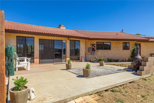 14320 Kiptree Dr, Lake Hughes, CA 93532 - rear view of property with a tiled roof, a patio, stucco siding, and a chimney